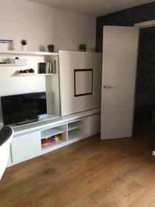 ein Wohnzimmer mit einem TV und einem weißen Entertainment-Center in der Unterkunft Gruissan Pleine vue sur port in Gruissan