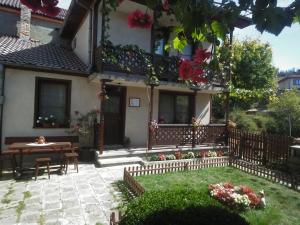 uma casa com uma mesa e um pátio em Guest Rooms Dona em Koprivshtitsa