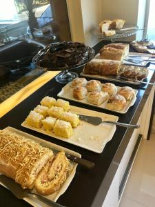 a buffet with different types of pastries on a counter at Hotel Ibicui in Rosário do Sul