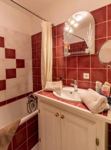 a bathroom with a sink and a mirror and a tub at Chambres d'hôtes au Freidbarry in Schillersdorf