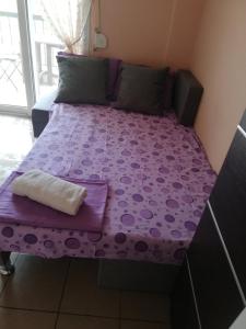 ネア・カリクラティアにあるApartment Sakisの紫色のマットレスが備わる客室の紫色のベッド1台分です。