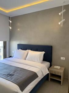 a bedroom with a large bed with a blue headboard at ZUR Studios and Suites in Beirut