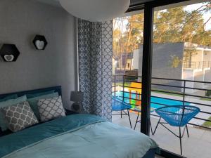 a bedroom with a bed and a balcony with a pool at Apartament Scandi N*.9 in Pobierowo