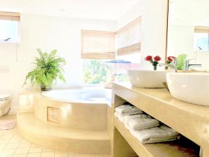 a bathroom with a tub and a sink at 5 Options Guest House in Bloubergstrand