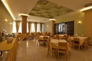 a restaurant with tables and chairs in a room at Park Hotel in Nafplio
