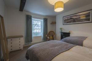 a bedroom with a bed and a dresser and a window at Finest Retreats - Tegannedd - Luxury Grade II Listed Cottage With Hot Tub in Ffestiniog