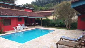 a swimming pool in front of a house at Linda casa Boicucanga in São Sebastião