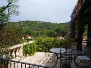 un patio con tavolo e sedie sul balcone. di La Terrasse a Reynès