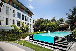 a swimming pool in front of a building at Red Mango Hotel and Apartments in Takoradi