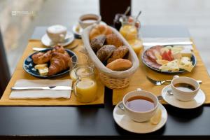 a table topped with plates of pastries and cups of coffee at Szitakötő Panzió in Fertőrákos