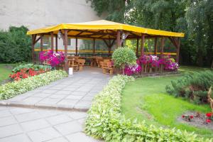 Deims Hotel في سيلوت: شرفة مع طاولات وزهور في حديقة