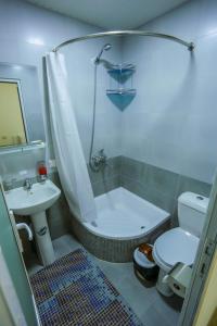 a bathroom with a tub and a toilet and a sink at Rudakiy Guest House in Bukhara