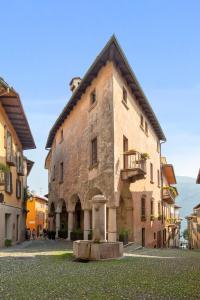 a large stone building with a fountain in a courtyard at Hotel Pironi in Cannobio