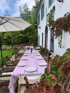een lange tafel met borden en glazen en een paraplu bij La Escribana in Constantina