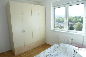 - une chambre avec des placards blancs et une fenêtre dans l'établissement HOLIDAY, à Novi Pazar