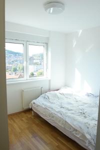 - une chambre blanche avec un lit et une fenêtre dans l'établissement HOLIDAY, à Novi Pazar