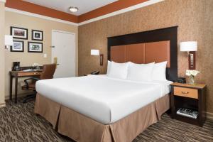 a large bed in a hotel room with a desk at The Hotel at Fifth Avenue in New York