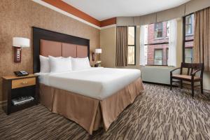 ein Hotelzimmer mit einem großen Bett und einem Stuhl in der Unterkunft The Hotel at Fifth Avenue in New York