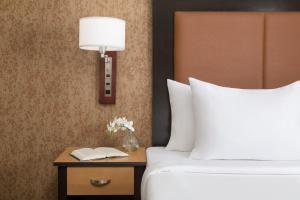 a hotel room with a bed and a table with a lamp at The Hotel at Fifth Avenue in New York