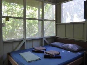 Yatama Rainforest Ecolodge في سارابيكي: غرفة مع سرير في غرفة مع نوافذ