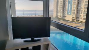 a television sitting on a table in front of a window at Departamento Papudo Laguna 120 in Papudo
