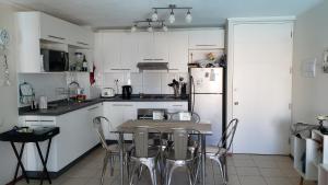 a kitchen with a table and chairs and a refrigerator at Departamento Papudo Laguna 120 in Papudo