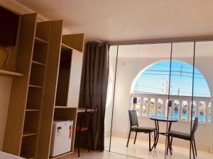 a dining room with a table and chairs and a window at Hotel Orla Guest House in Petrolina