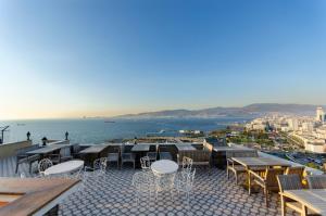a patio with tables and chairs and a view of the water at Büyük Konak İzmir in Izmir
