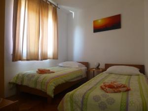 a bedroom with two beds and a window at Apartment Dada in Novi Vinodolski