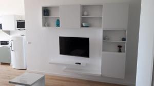 ein weißes Wohnzimmer mit einem TV an der Wand in der Unterkunft Rosa di mare in Bari