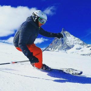un hombre está esquiando por una montaña cubierta de nieve en Marcolski home en Breuil-Cervinia