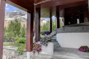 a porch of a house with flowers on the stairs at Marcolski home in Breuil-Cervinia