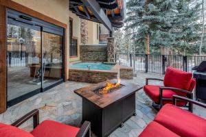 a patio with a fireplace and a hot tub at Creekside at Beaver Creek in Beaver Creek