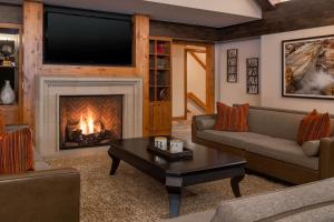 a living room with a fireplace and a tv at Creekside at Beaver Creek in Beaver Creek