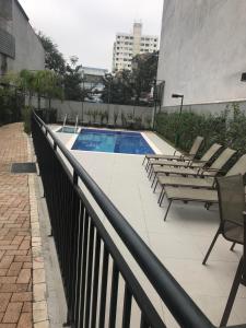 una piscina con sedie a sdraio sul balcone di Studio expo norte Bras SP feira da madrugada a San Paolo