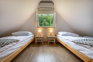 two beds in a room with a window at Dobre Miejsce in Ustrzyki Dolne