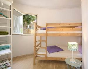 a bedroom with two bunk beds with a ladder at Il giardino di sabbia in Lacona
