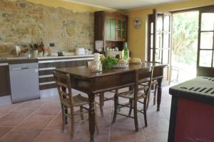 - une cuisine avec une table en bois et des chaises dans l'établissement CàMia, à Torrazza Coste
