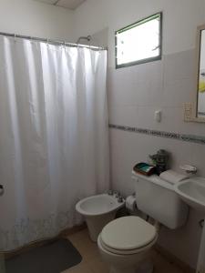 Baño blanco con aseo y lavamanos en Complejo Sarmiento 1 en Formosa