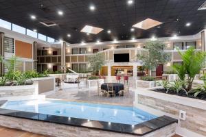 eine große Lobby mit einem großen Pool in der Mitte in der Unterkunft LeBossier Hotel in Bossier City