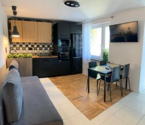 een keuken en een woonkamer met een tafel en stoelen bij D&M Apart Interior Styles in Białystok