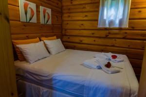 a bed in a wooden room with towels on it at Hotel Brisa do Japi in Cabreúva +118 photos