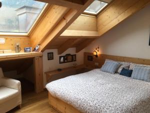 ein Schlafzimmer mit einem Bett mit blauen Kissen und einem Fenster in der Unterkunft Mansarda Dolomiti in Oberrasen