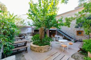 un patio con un árbol, mesas y sillas en Dutlu Konak en İzmir