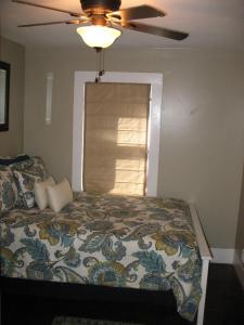 a bedroom with a bed with a ceiling fan at The Cottage at Castle Rock in Bisbee