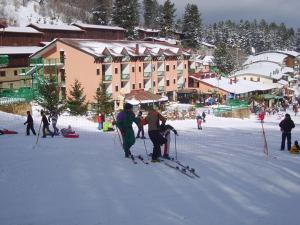 un gruppo di persone sugli sci nella neve vicino a una tenuta di Hotel Lo Scoiattolo a Cotronei