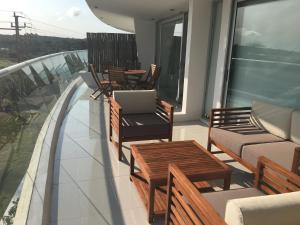 d'un balcon avec des chaises, des tables et un ordinateur portable. dans l'établissement Depto 203 Edificio Bikini Beach, Manantiales, à Punta del Este 4 autres photos