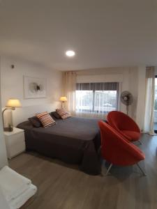 a bedroom with a large bed and a red chair at The Place in Madaba