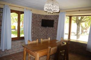 una sala da pranzo con un tavolo e una tv di SOL PATAGONICO a Playas Doradas