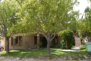 una casa con due alberi davanti di SOL PATAGONICO a Playas Doradas